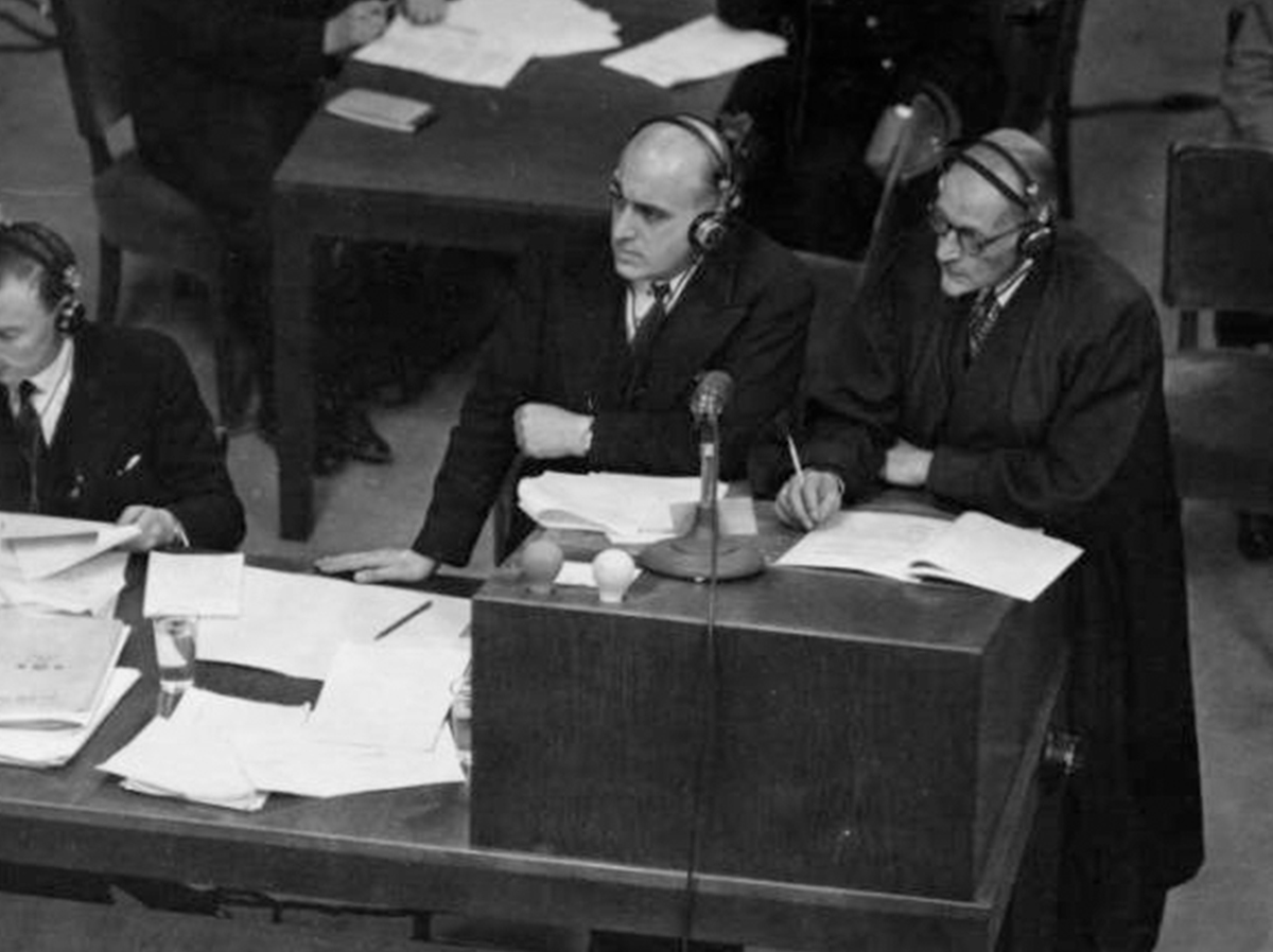 One of the key writers of the European Convention on Human Rights was British Conservative MP and lawyer David Maxwell-Fyfe. This image shows Maxwell-Fyfe at the Nuremburg trials - the image is of two men stood at a table, covered in papers and microphones. They are listening to a court trial, and they are wearing headphones so they can hear the translations of the trials. 