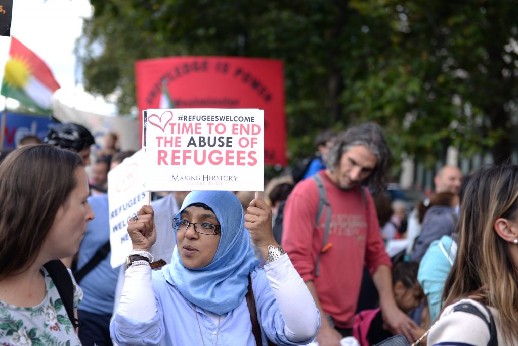 A woman protesting for refugee and asylum rights