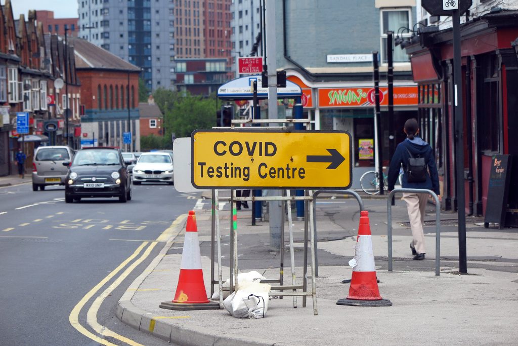 A sign pointing to a coronavirus testing centre in an article about self-isolation rights 