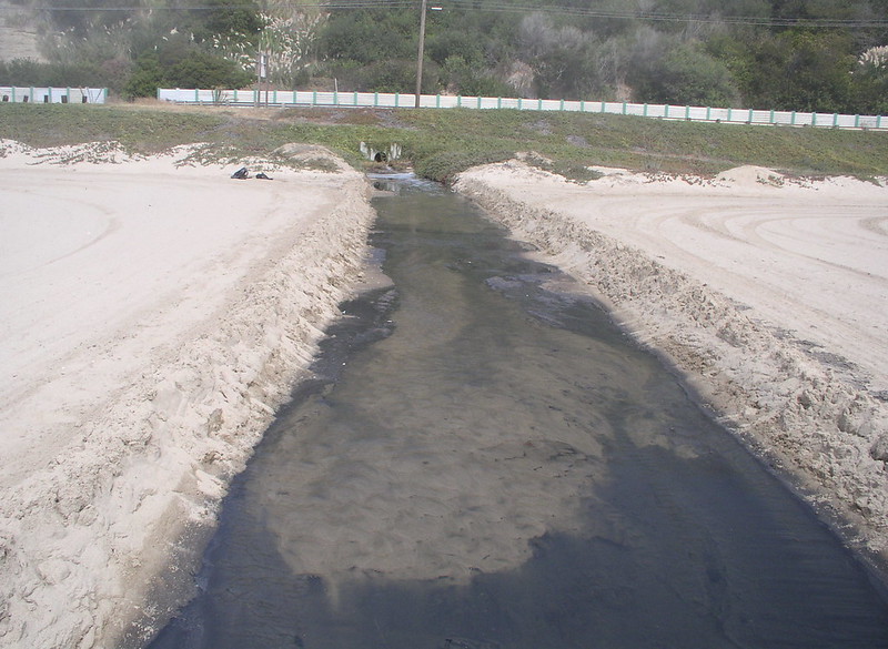 Sewage seeps into a waterway from a pipe