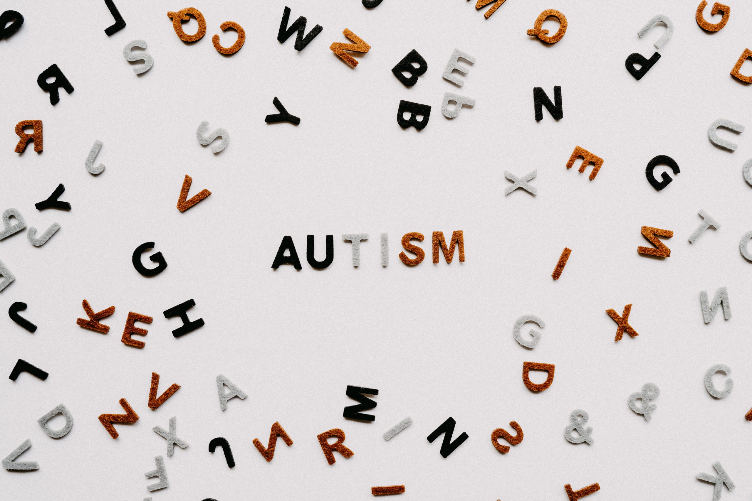 The word is autism is spelt out using letters in the middle of a scattering of other multi-coloured letters