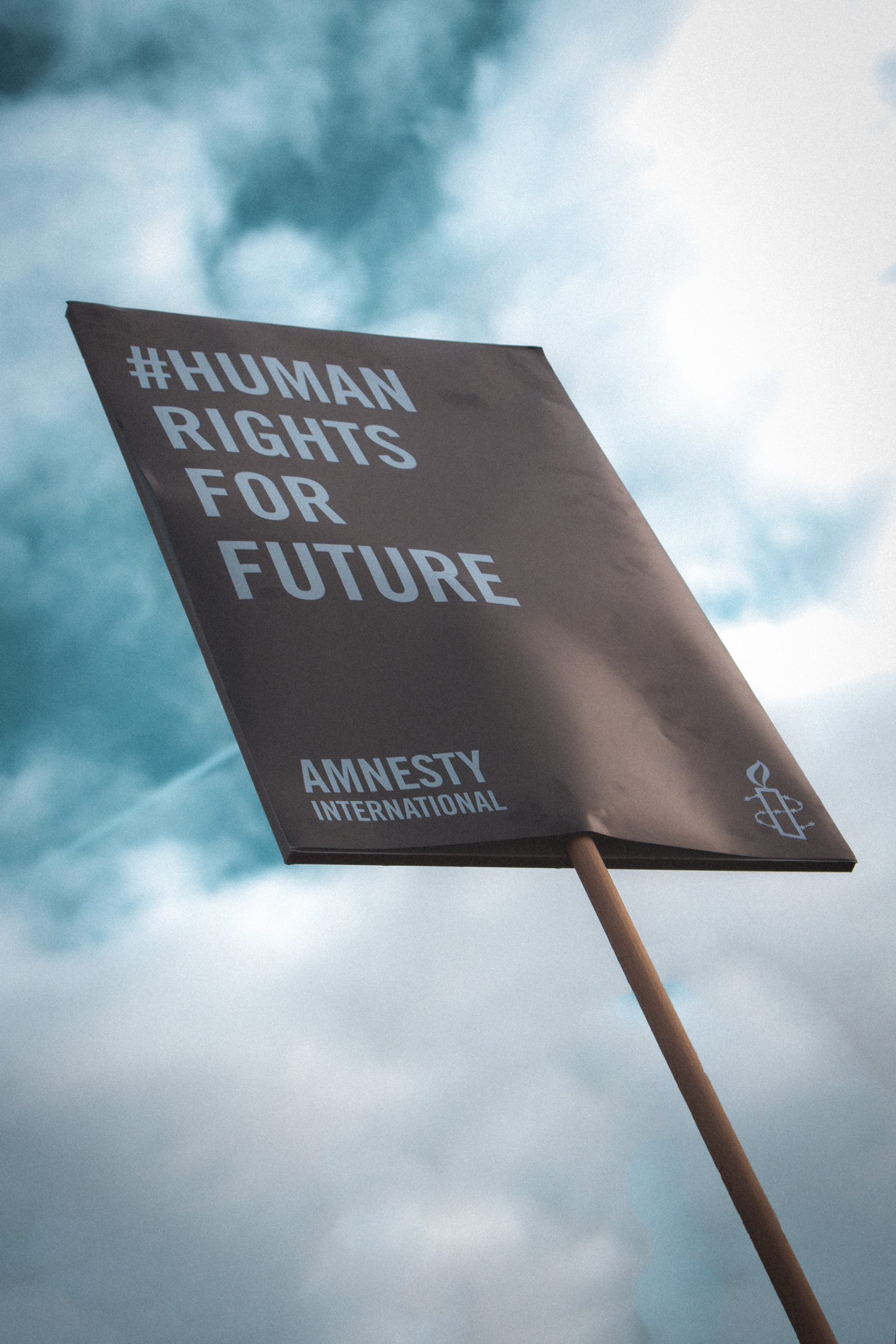 A protest signs reads "human rights for future" on black card