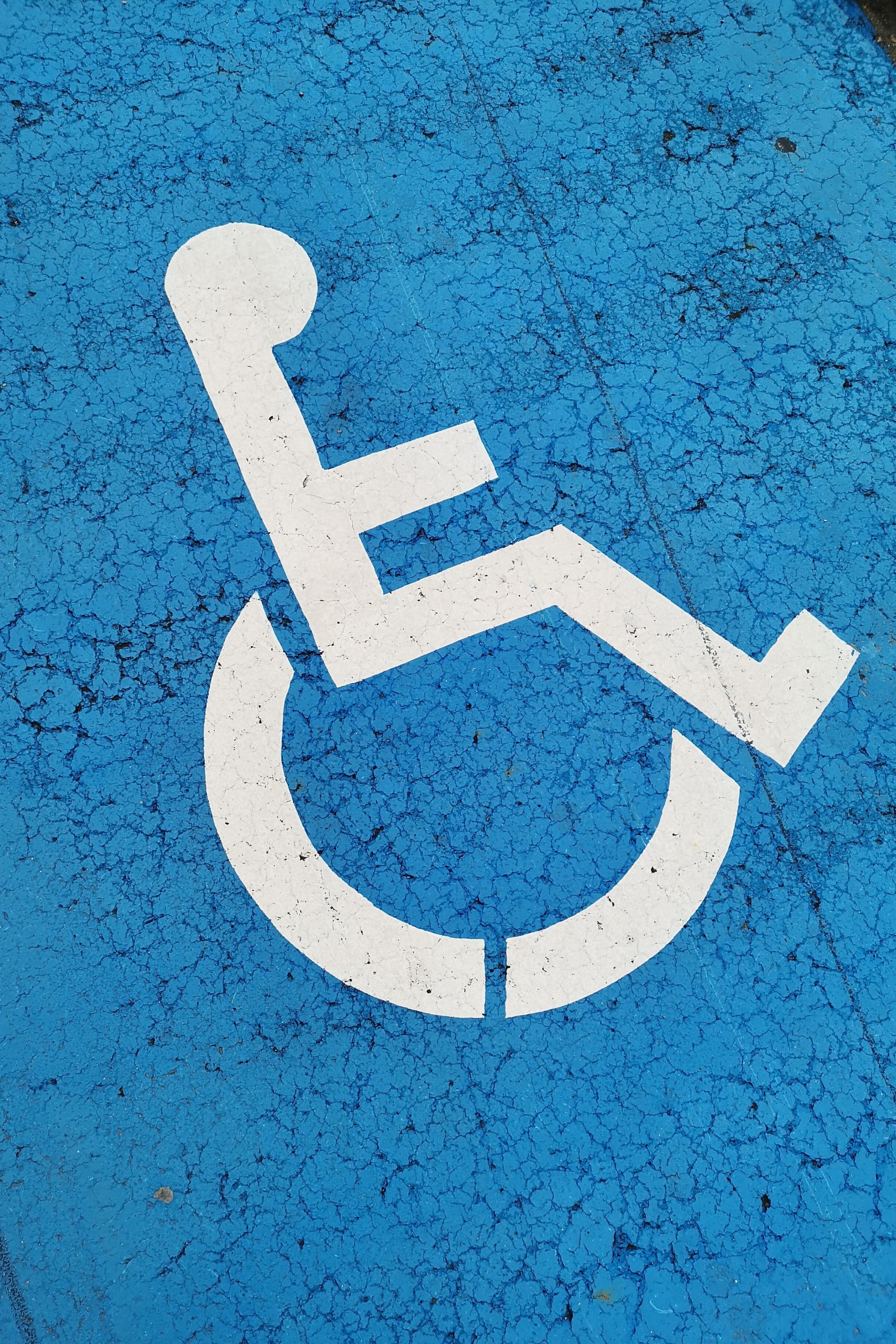 A portrait photo is filled with the disability symbol against a blue background