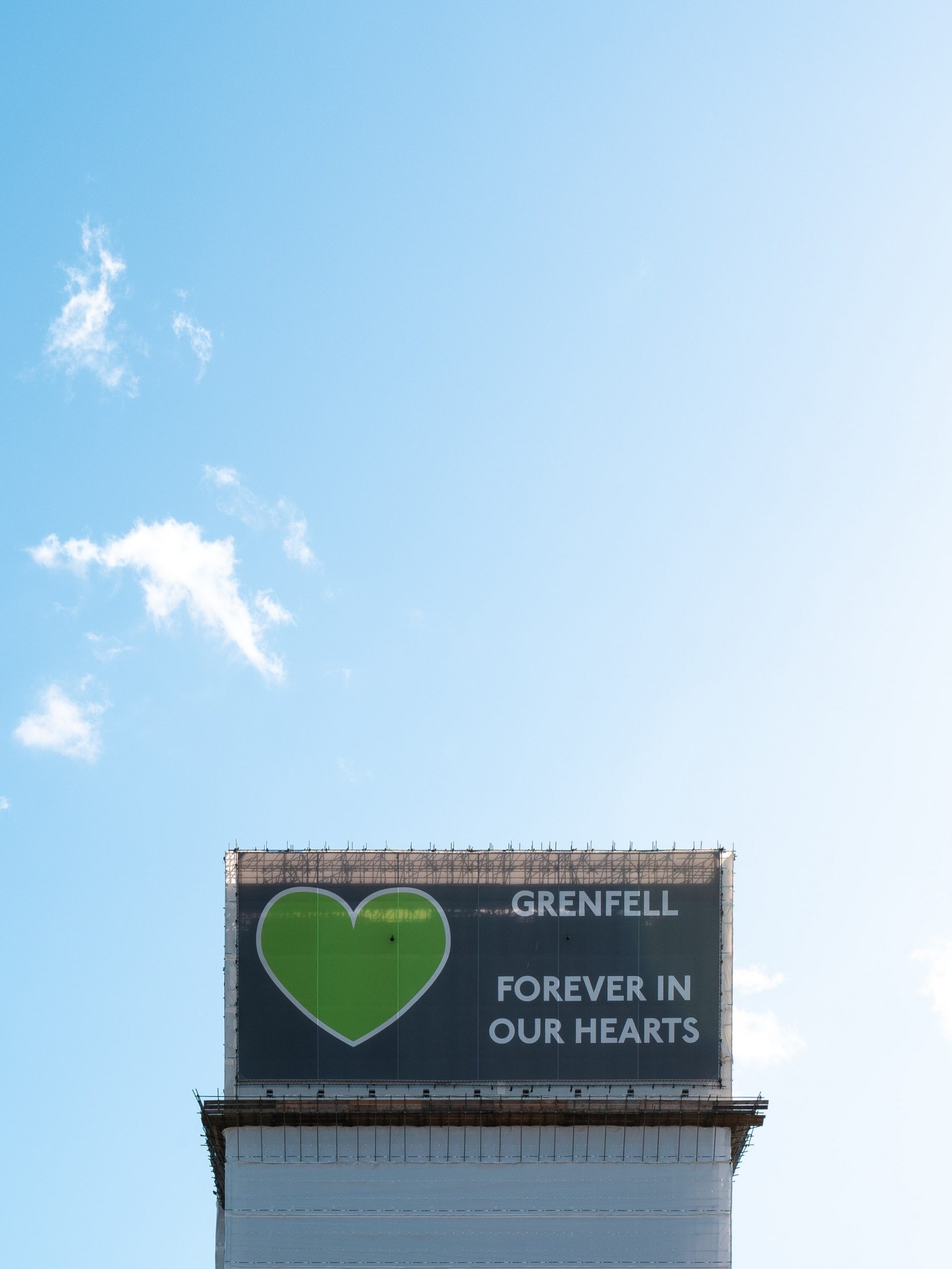 A close up of the top of the Grenfell tower reads "Grenfell forever in our hearts" 