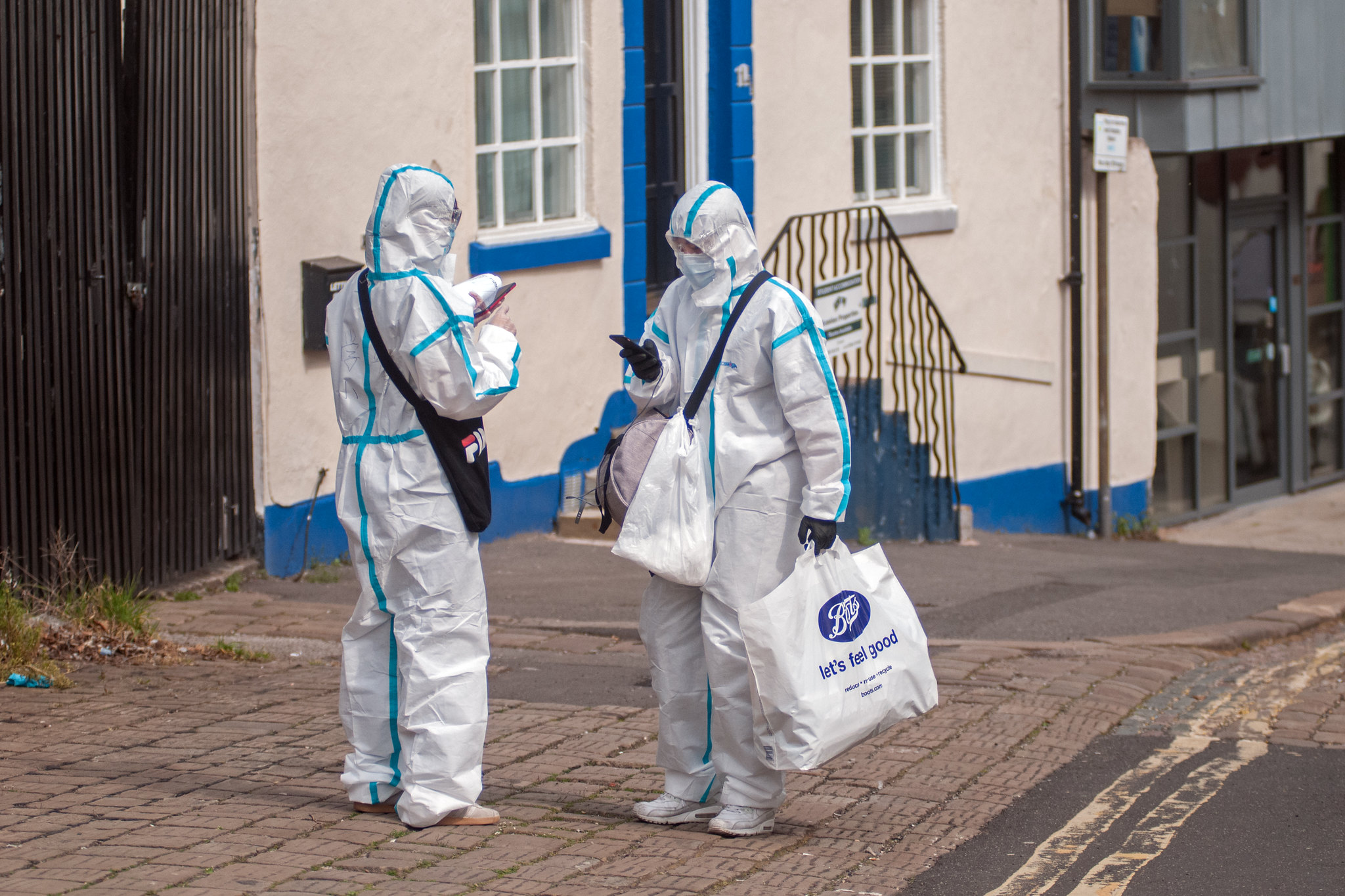 Two people in Haz-mat suits deliver prescriptions.