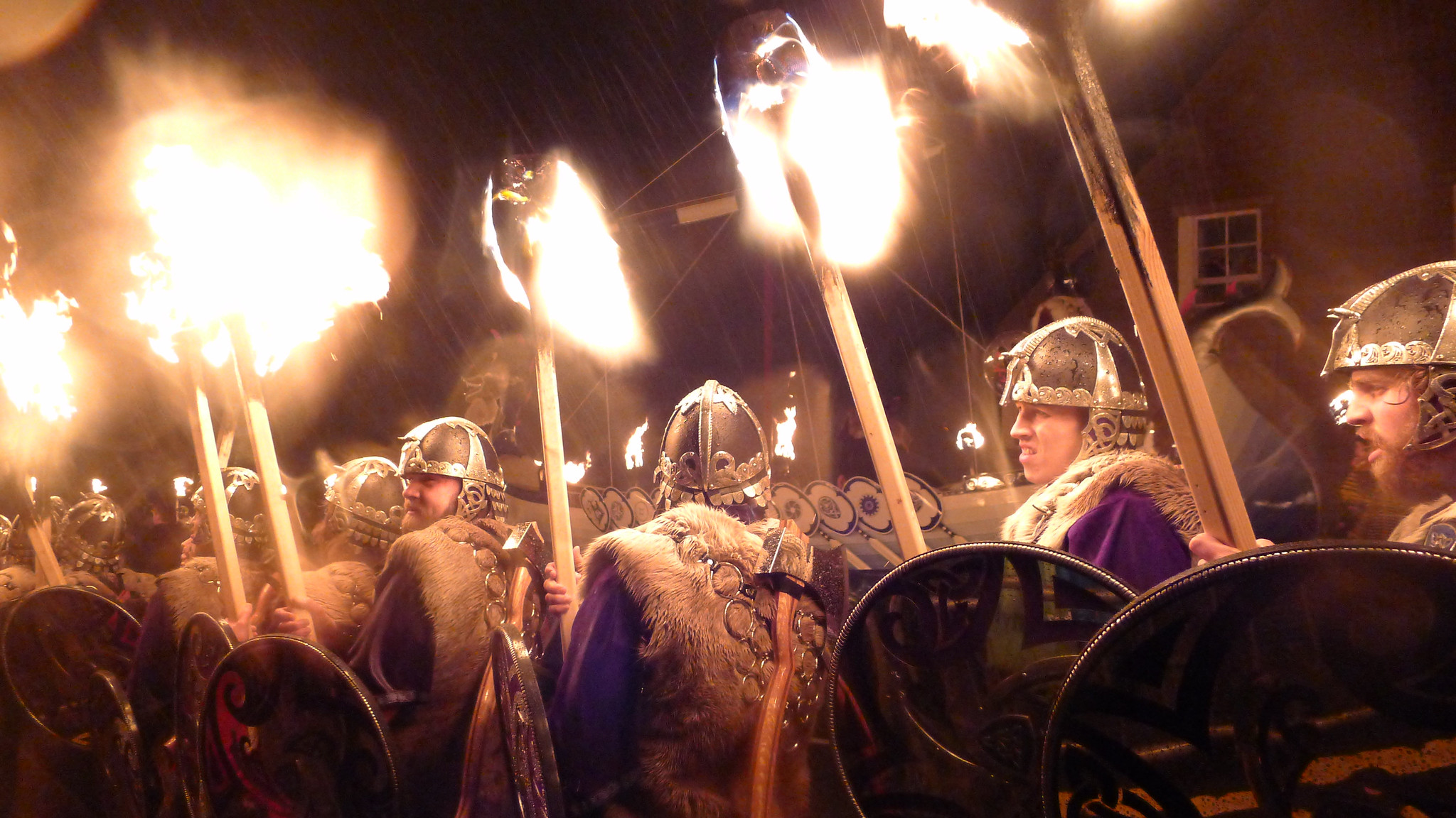 A group of men dressed as vikings lead a procession