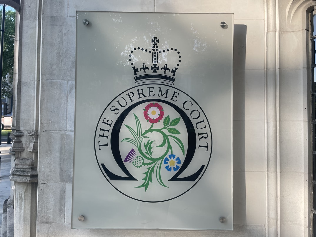 The logo of the UK Supreme Court, with three flowers and a crown