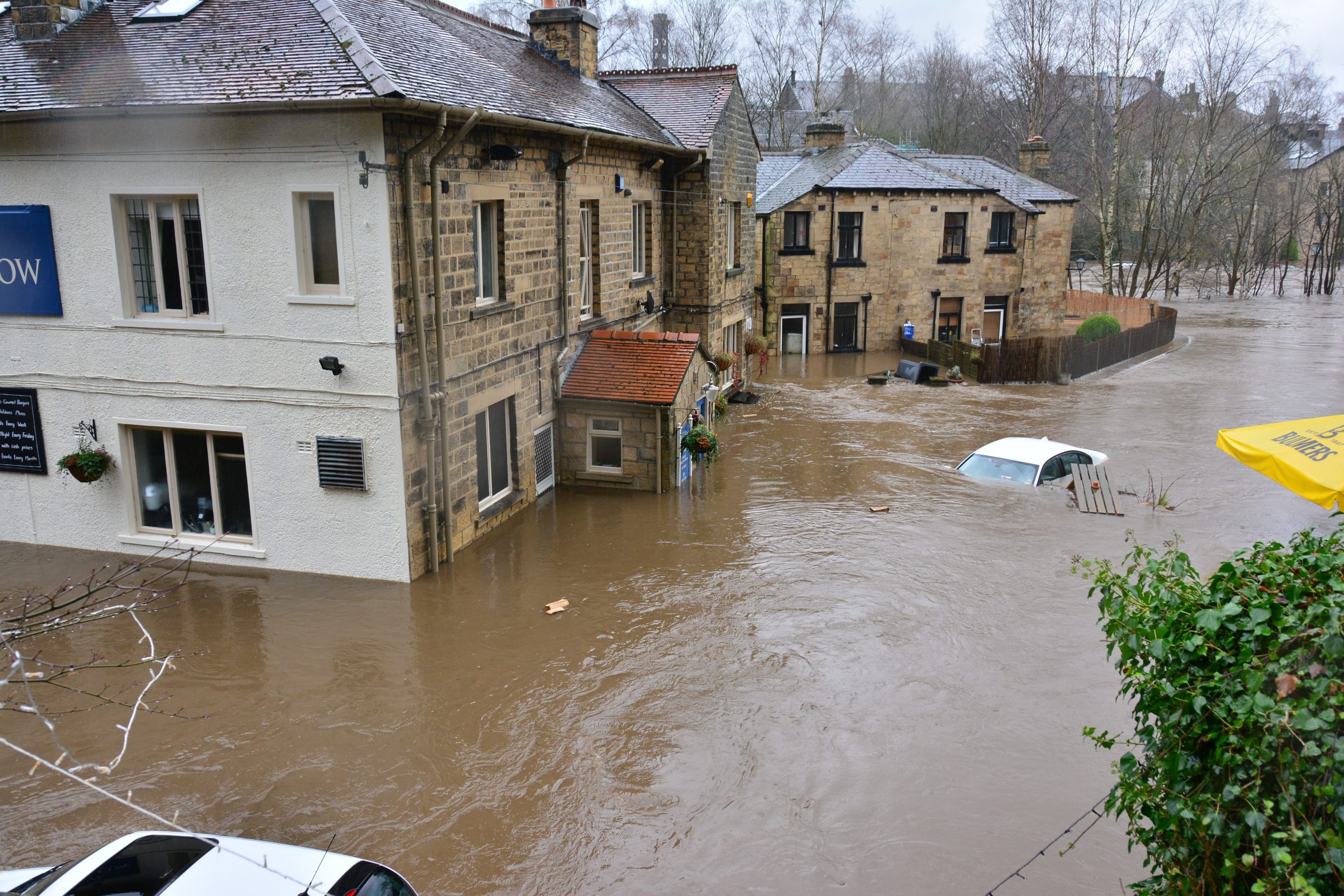 A wideshot shows rural houses in England flooded