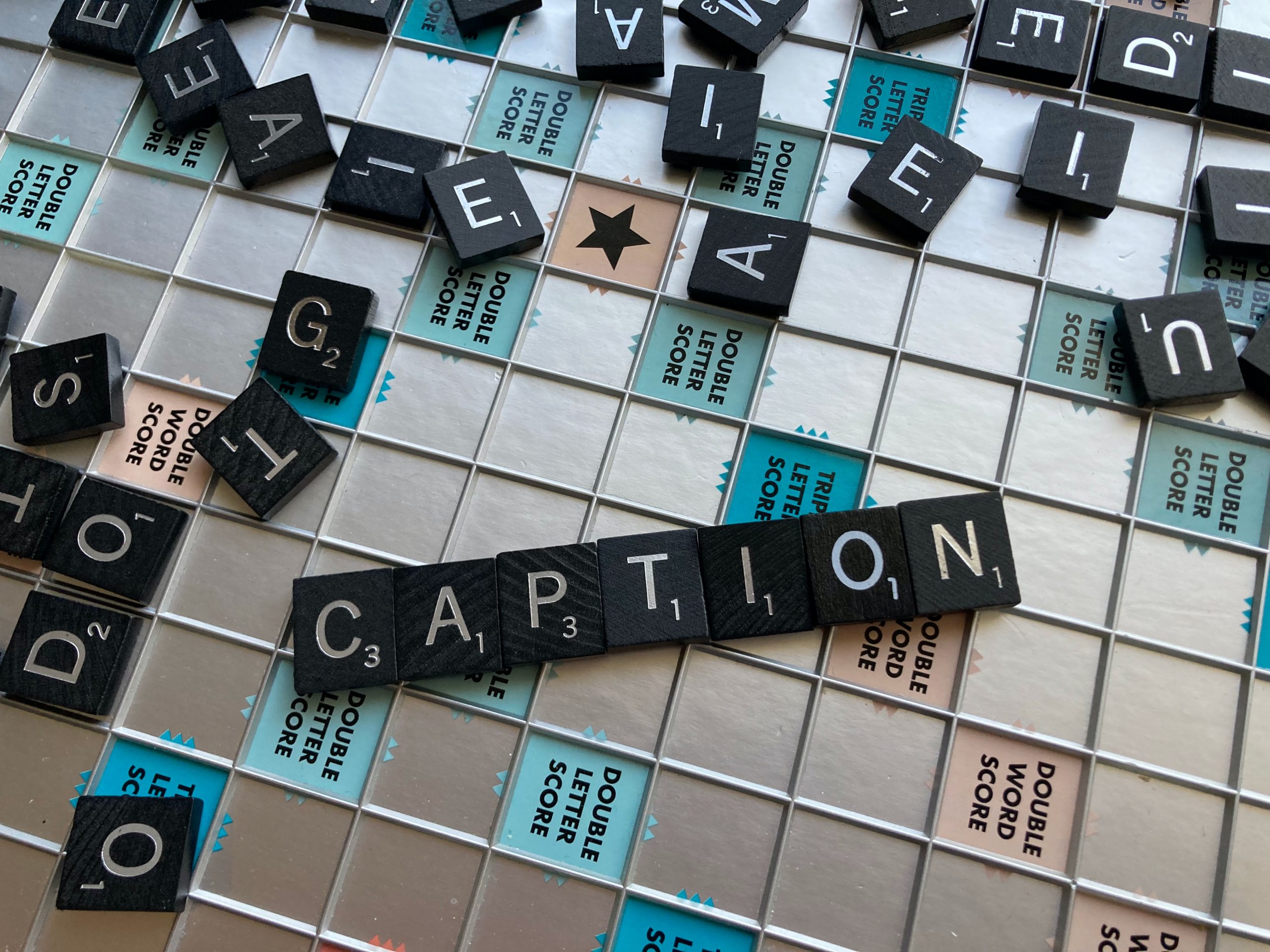 Scrabble board spelling out CAPTION