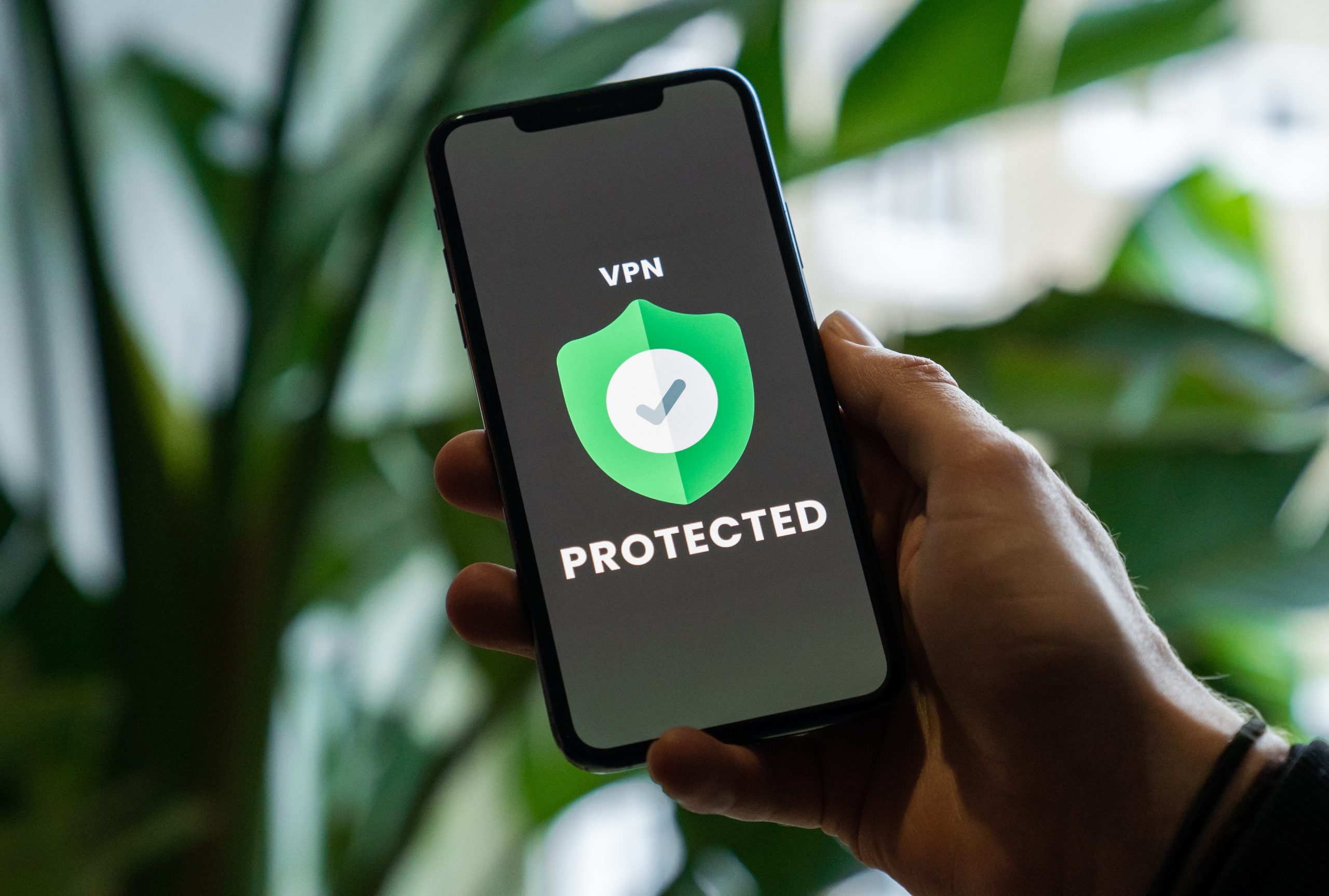 A phone screen shows a green shield with a black tick in a white circle. Text reads "protected" 