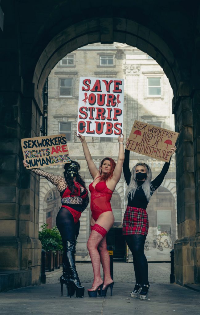 A group of activists hold signs that read: "Save our strip slubs"