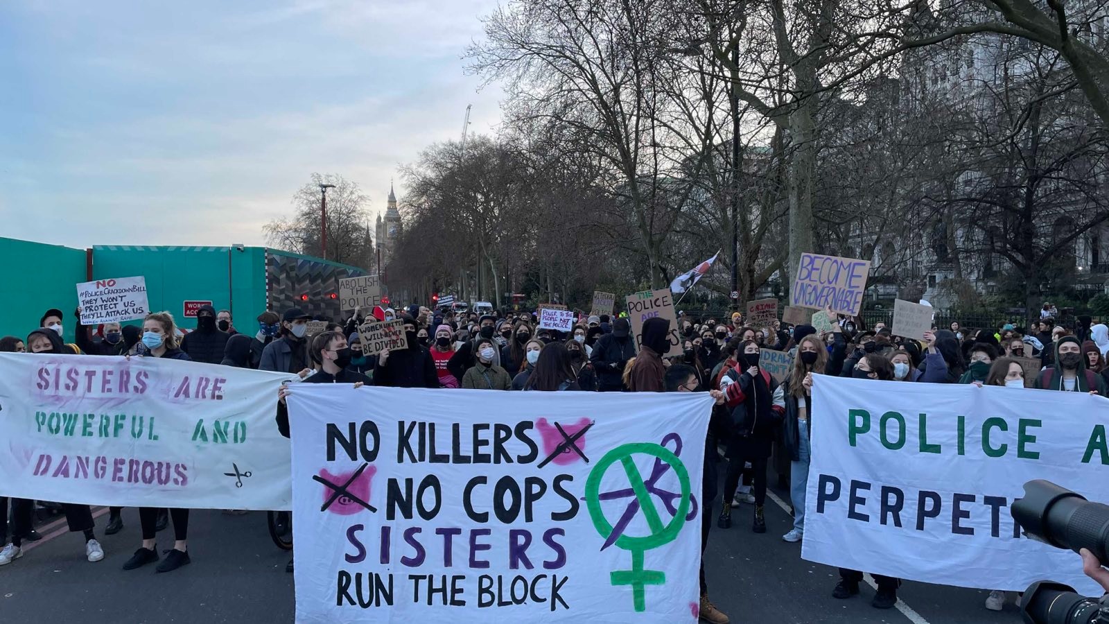 A Sisters Uncut sign reads: 'No killers No cops, Sisters run the block'