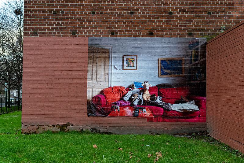 Street art shows the inside of a house painted onto a brick wall