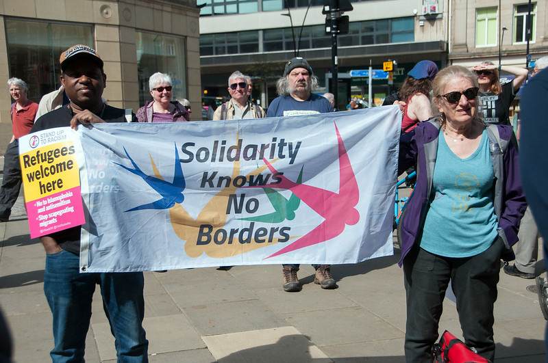 Protesters hold banner reading: "Solidarity knows no borders"